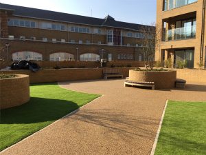 Buff resin bound pathway between lawns at a residential development
