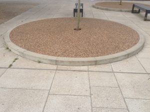 Circular resin bound tree pit set into paving slabs