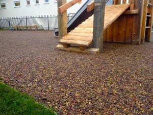 Bonded rubber mulch safety surface under a timber play frame