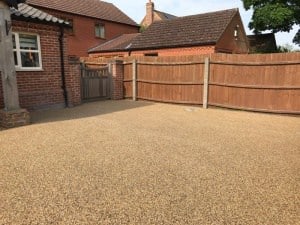 Buff resin bound driveway with a timber fence and gates