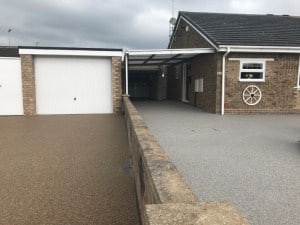 Grey resin bound driveway leading to a garage