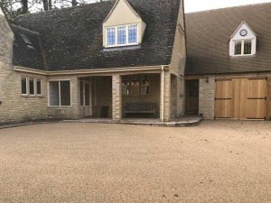 Resin bound courtyard driveway at a Cotswold stone house with a garage