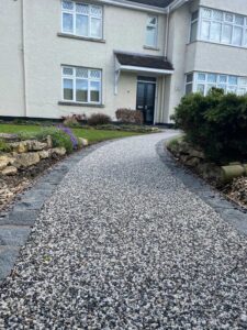 Curving silver-grey resin bound path to a front door