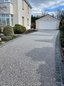 Silver-grey resin bound driveway leading to a garage