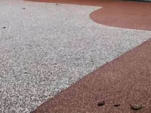 Silver-grey and red resin bound driveway with a curved border