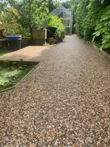 Long resin bound garden path beside a hedge