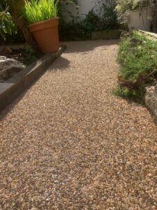 Narrow resin bound garden path between planted beds