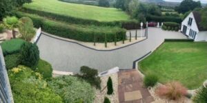 Grey resin bound driveway winding down a landscaped garden