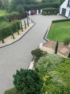 Resin bound driveway and terraced planting on a sloping garden