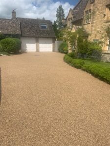 Resin bound driveway leading to a Cotswold stone garage