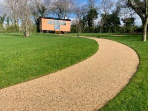 Curving resin bound path across a lawn to a garden building